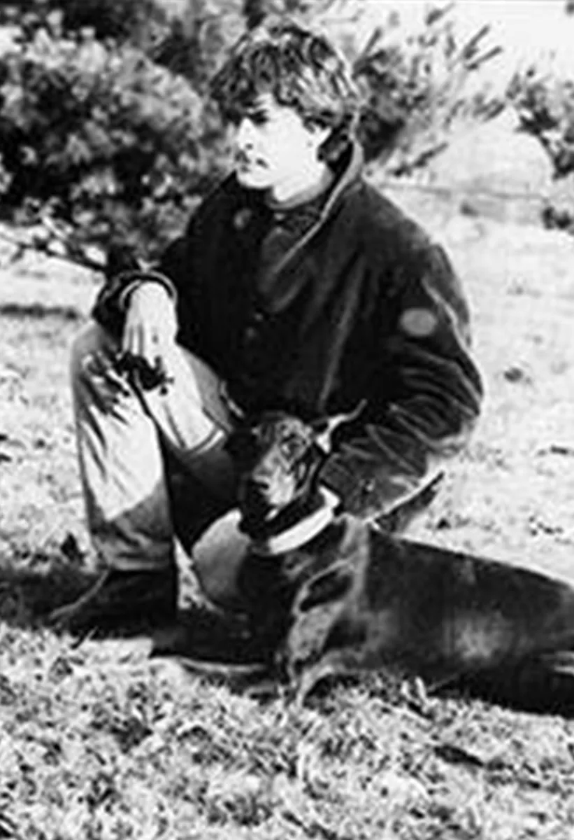 Mauro Luccardini da ragazzo seduto sul prato accanto al suo Dobermann, foto in bianco e nero